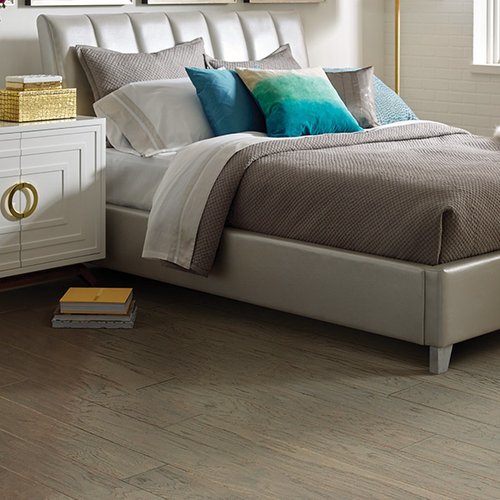 Grey bed on hardwood flooring from Prestige Flooring Center in Cathedral City, CA
